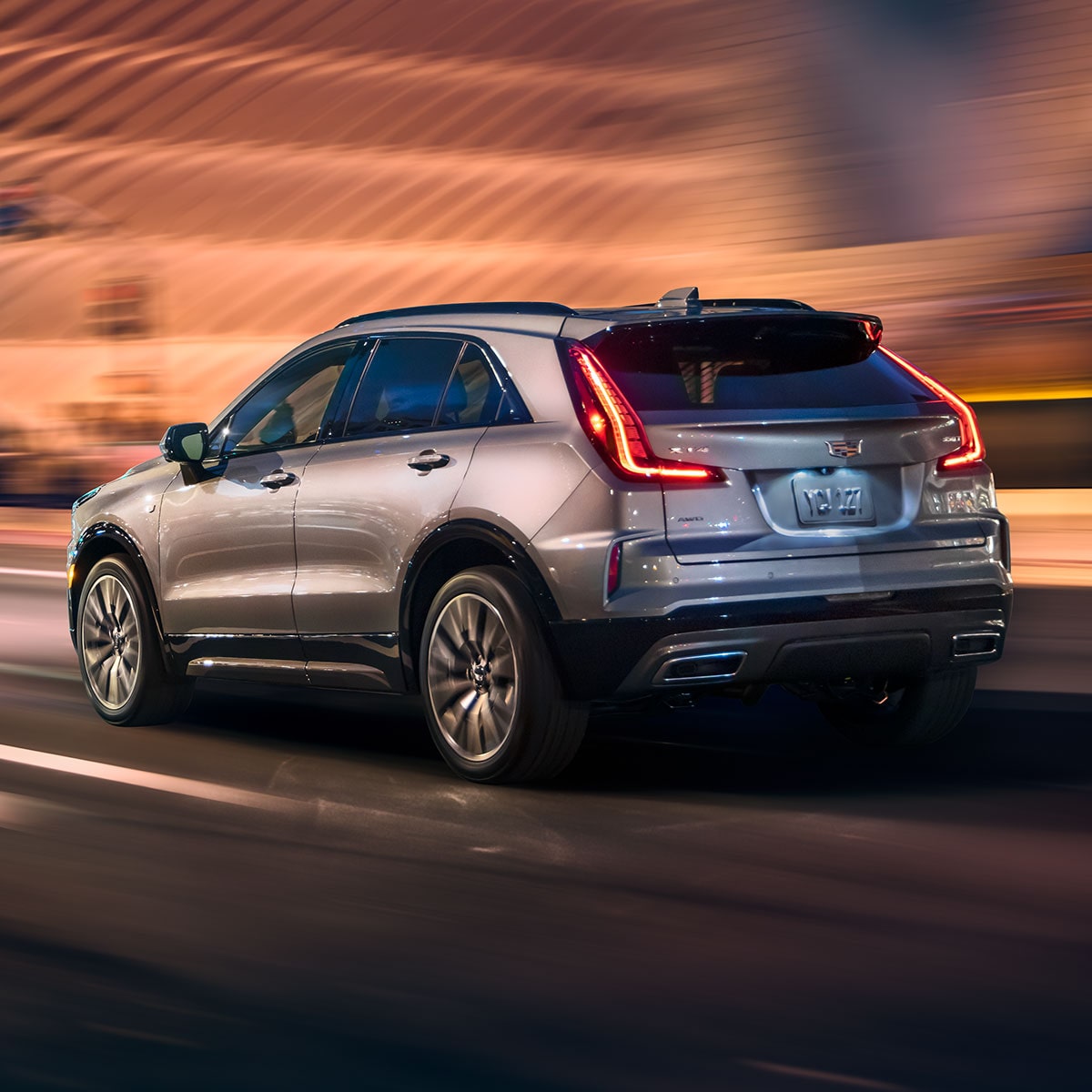 Rear View of the 2025 Cadillac XT4 Driving Fast Through the City at Night