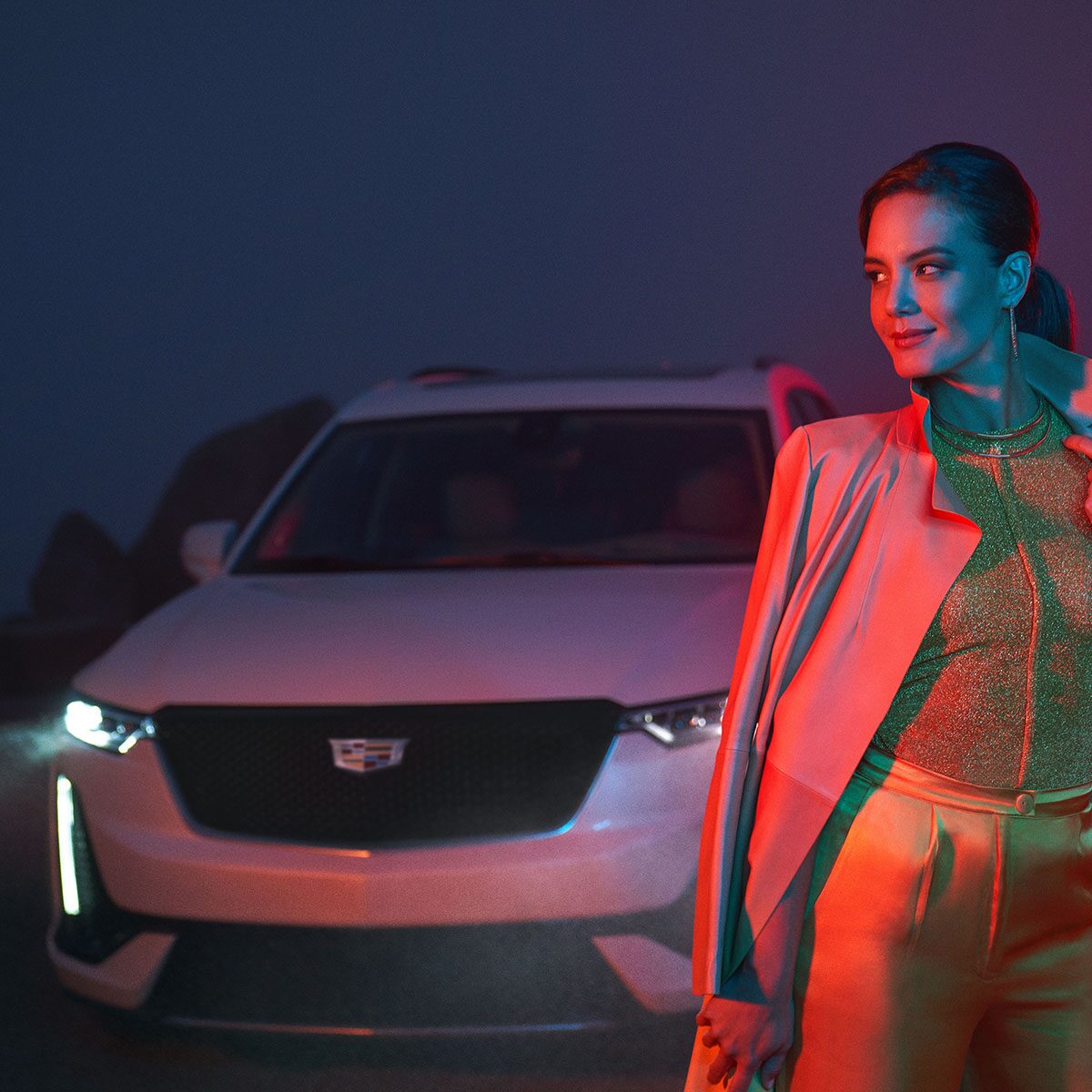 A Woman Poses in Front of the Cadillac XT6 During the Night
