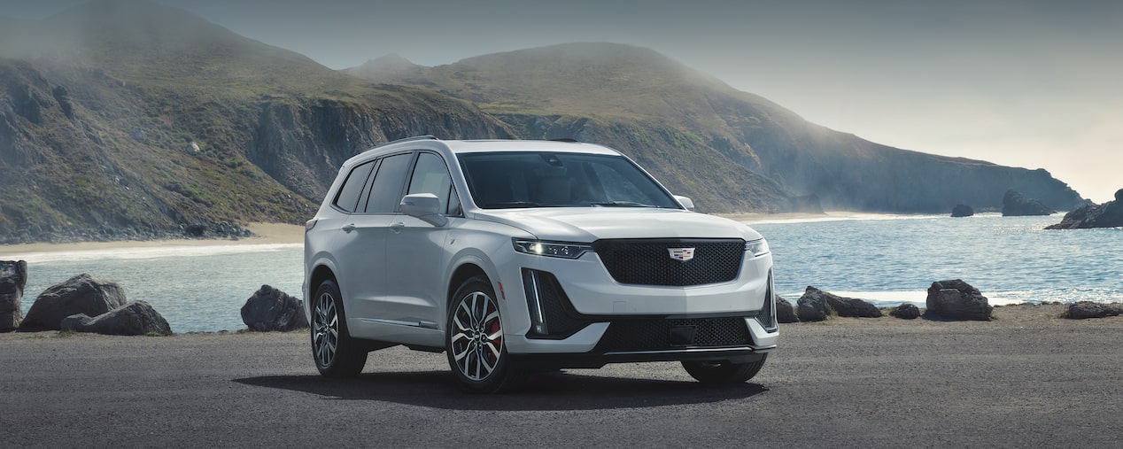 The Cadillac XT6 Parked Along the Coast with an Incredible View of Mountains and Ocean