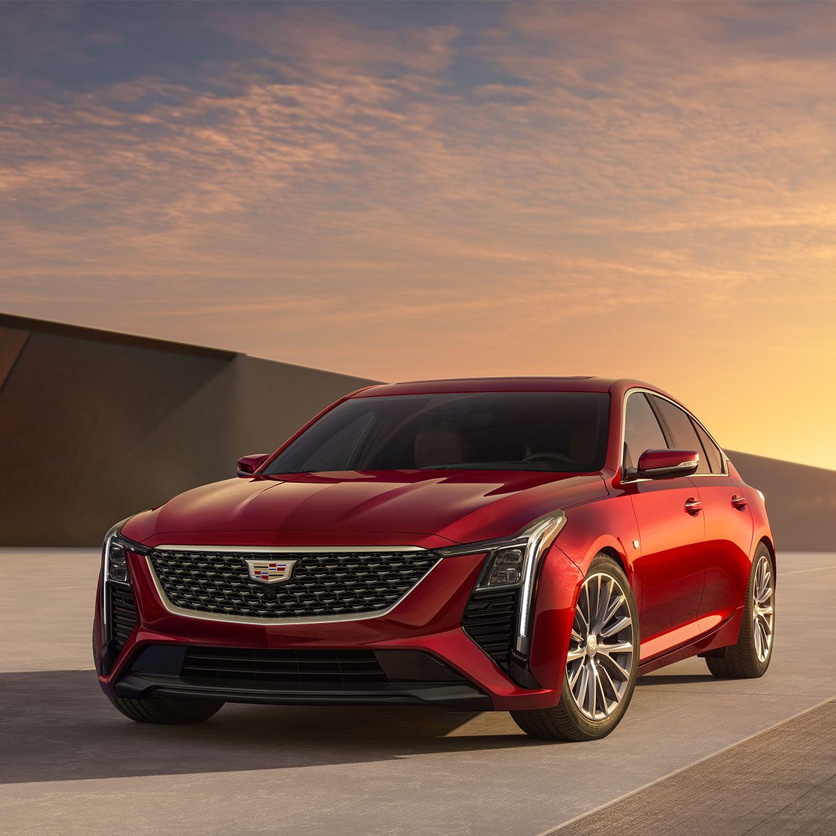 Front Driver's Side View of Parked Red 2025 Cadillac CT5 With Beautiful Sun Setting Displayed