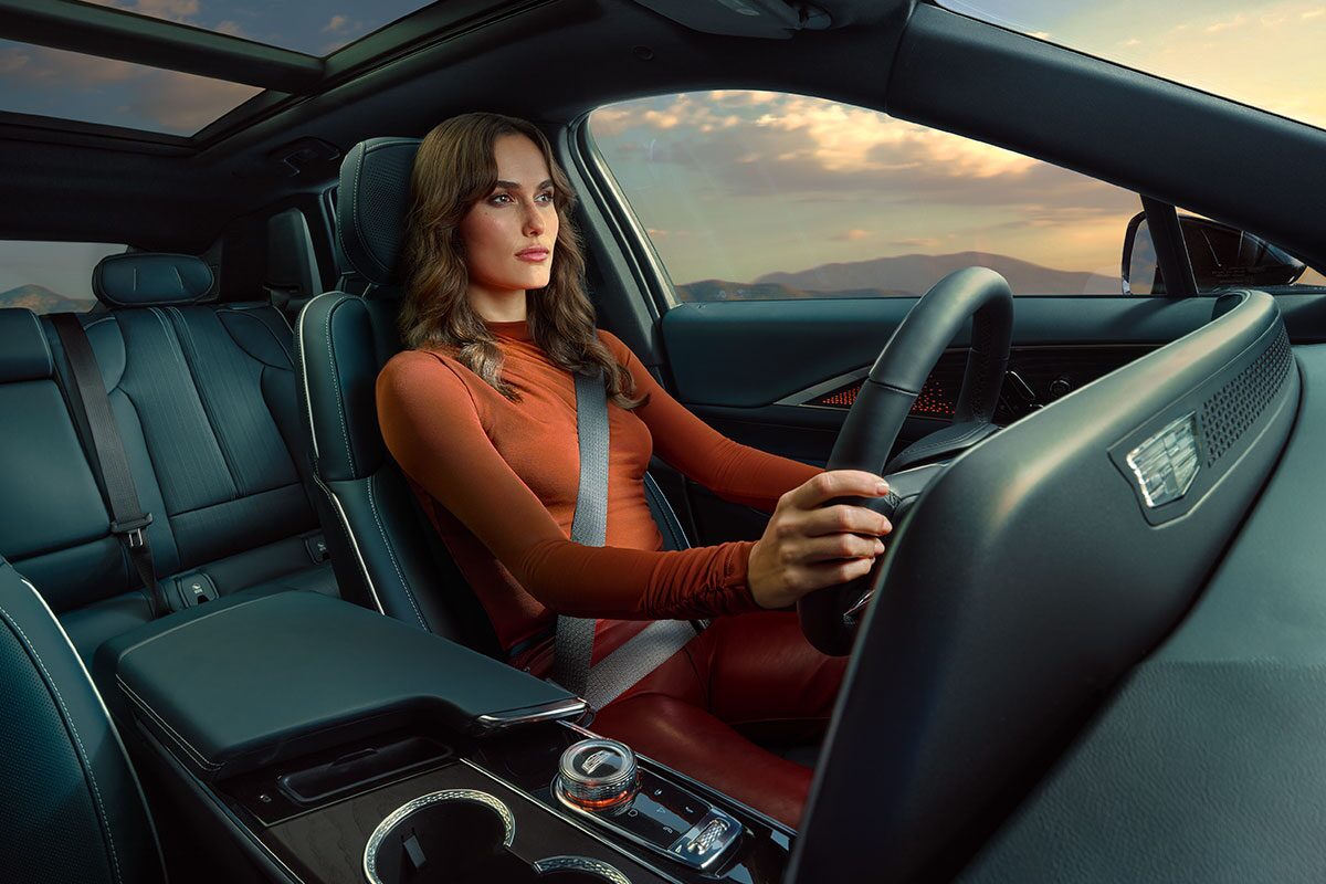 Dashboard View of a Woman Driving a 2025 Cadillac LYRIQ Outlooking the Mountains