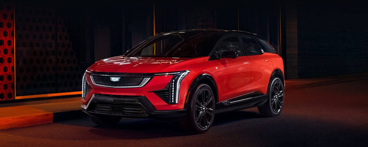 Three-quarter View of a Red 2025 Cadillac OPTIQ Parked on a Dark Street