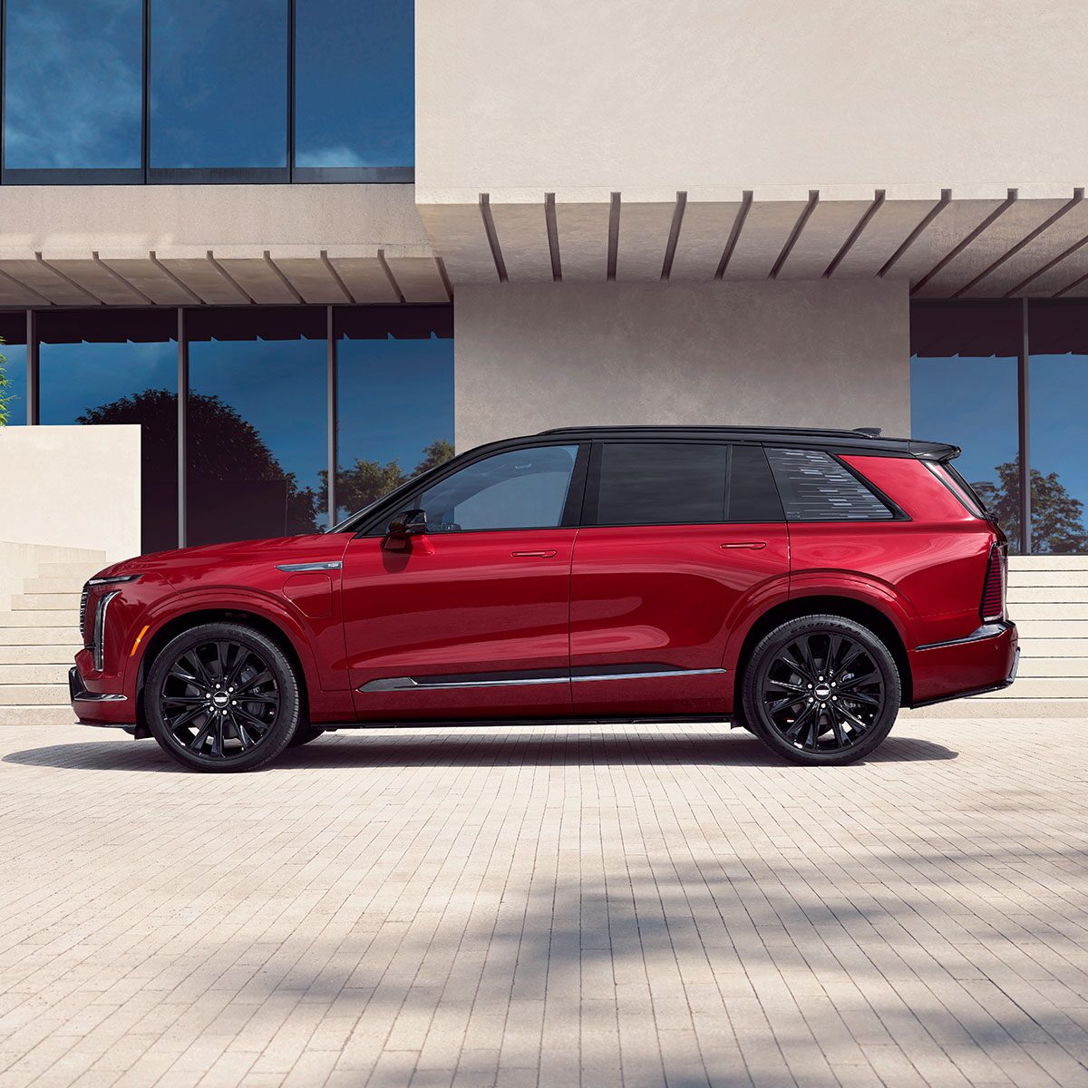 Profile View of the Red 2026 VISTIQ Parked on a White Brick Driveway Outside a Modern Home