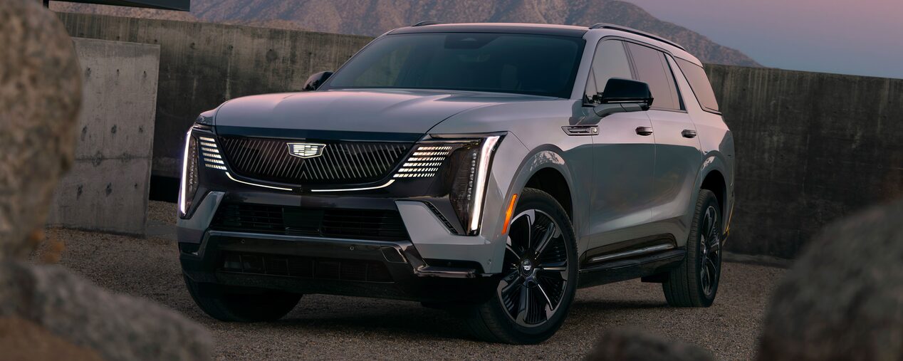 Front Three-Quarter View of the 2026 ESCALADE IQL Parked near a Concrete Wall During Dusk