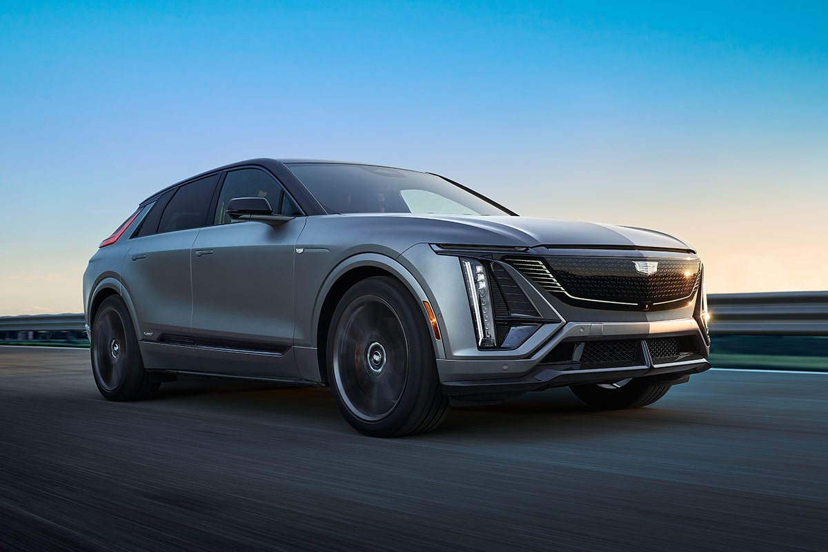 Three-quarter Passenger Side View of a Silver 2026 Cadillac LYRIQ-V Electric SUV Driving Down a Road