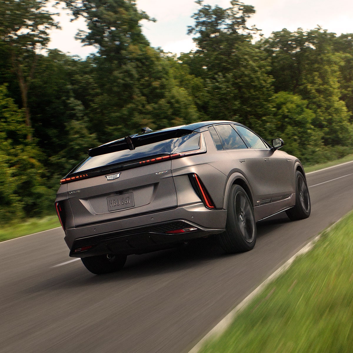 Rear View of a Cadillac LYRIQ-V Performance EV Driving Down a Road