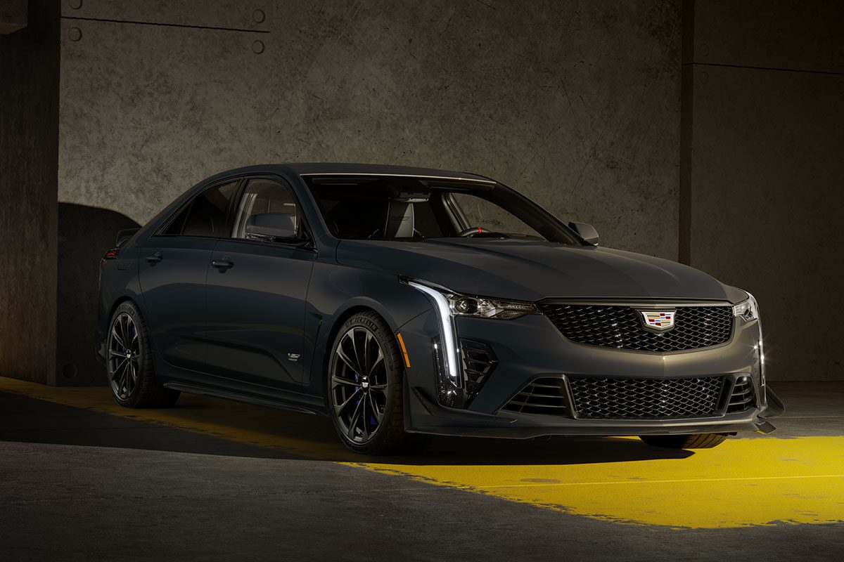 A Dark Gray Cadillac CT4-V Blackwing Sedan Parked on a Yellow-Striped Concrete Floor in a Dimly Lit Garage