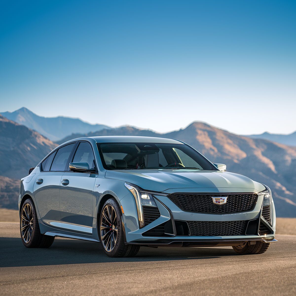 Three-Quarters View of a Light Blue Cadillac CT5-V in a Desert with Mountains Visible in the Distance