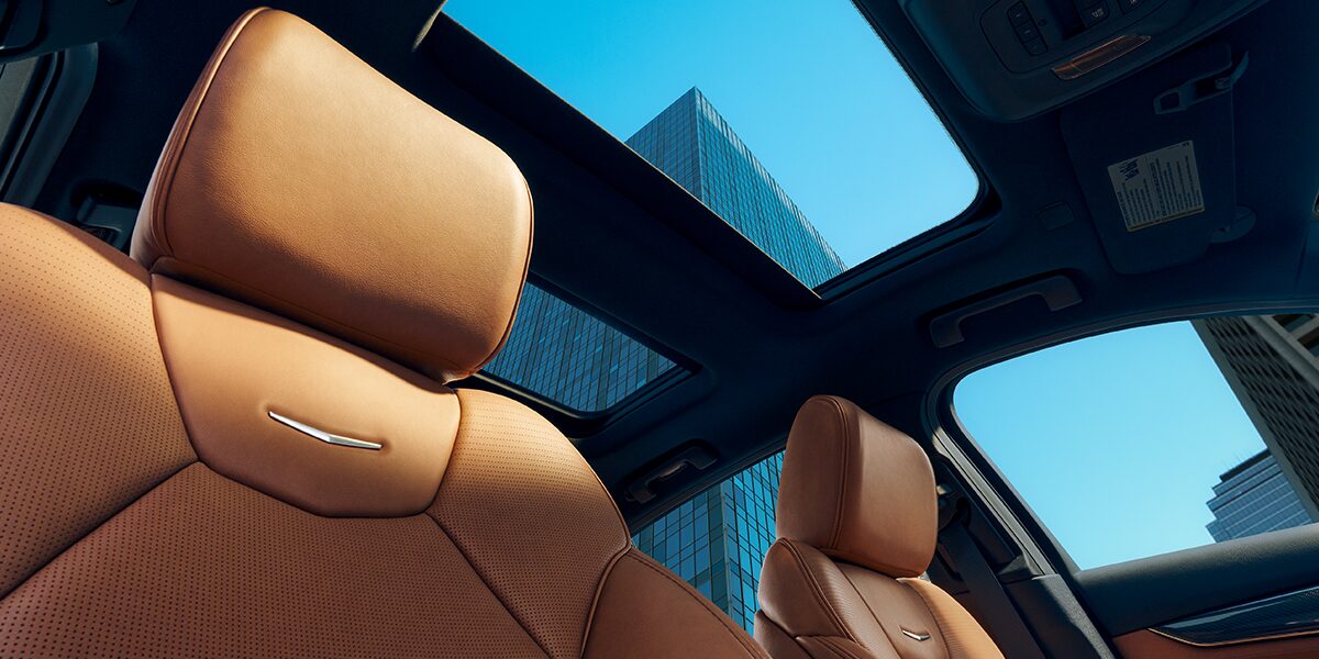Sun Shining on 2026 Cadillac CT5 Crest on Front Leather Seats and View of Sun Roof