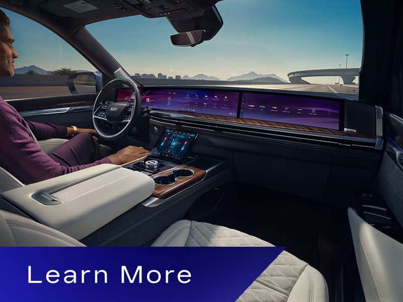 A Man Driving the Cadillac Escalade  Utilizing the Hands-free Super Cruise Feature