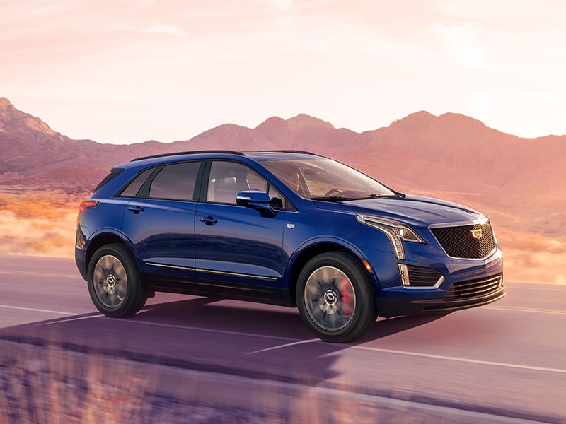 The 2026 Cadillac XT5 Driving Through a Western Landscape During Golden Hour