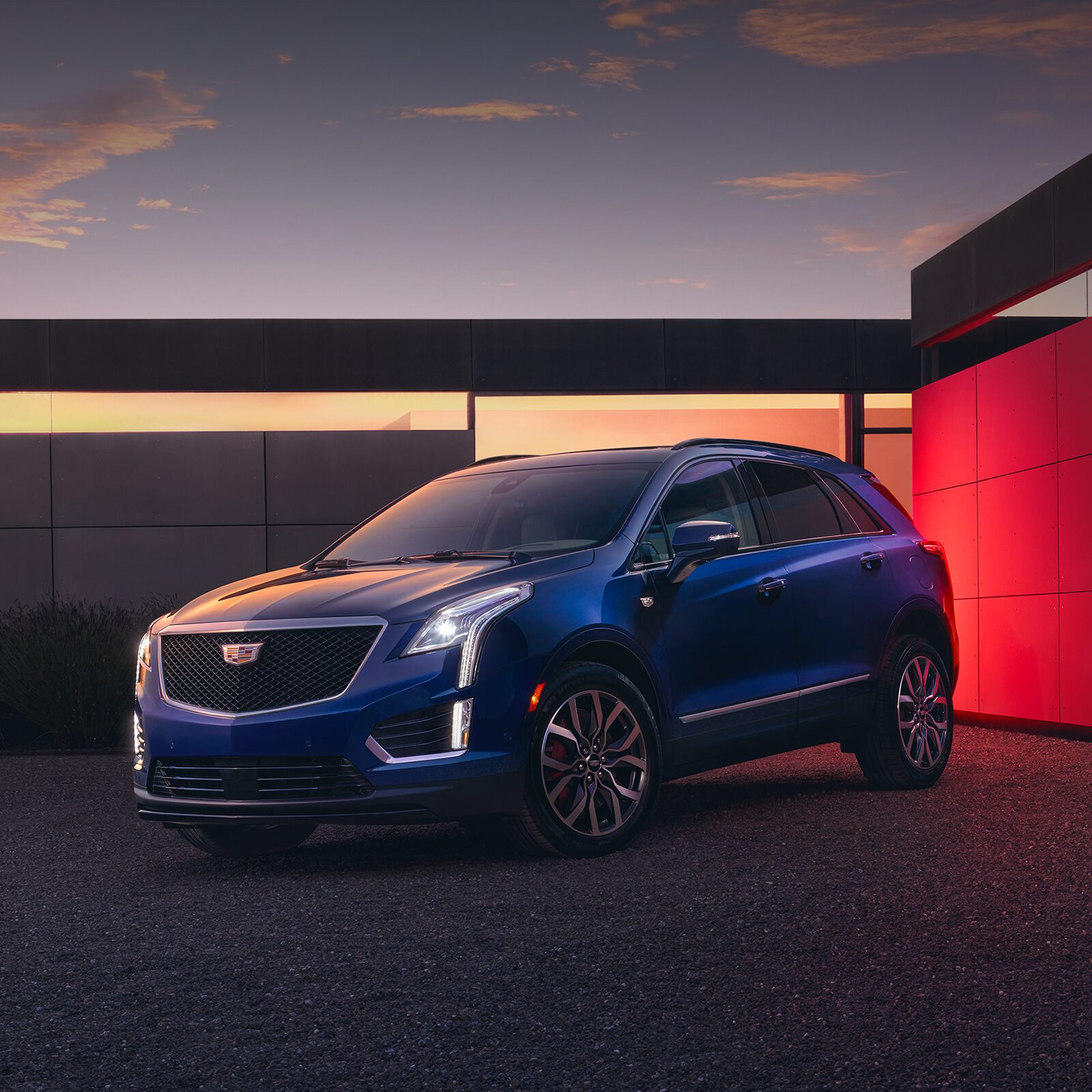 The Beautiful 2026 Cadillac XT5 Parked at Dusk in Front of Modern House With Lights On