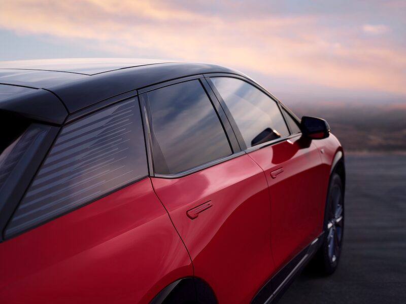 Side Passenger Exterior View of a Red 2027 Cadillac OPTIQ