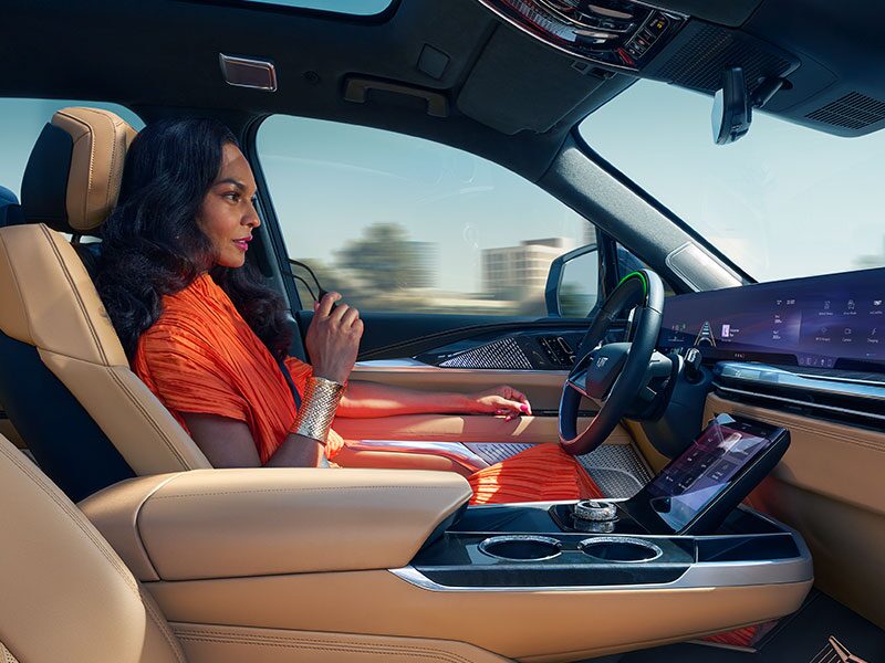 Passenger View of a Woman Driving a Cadillac with Hands Off the Steering Wheel and Utilizing the Super Cruise Feature